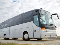 Automotive quality float glass surrounds this white commercial transport bus